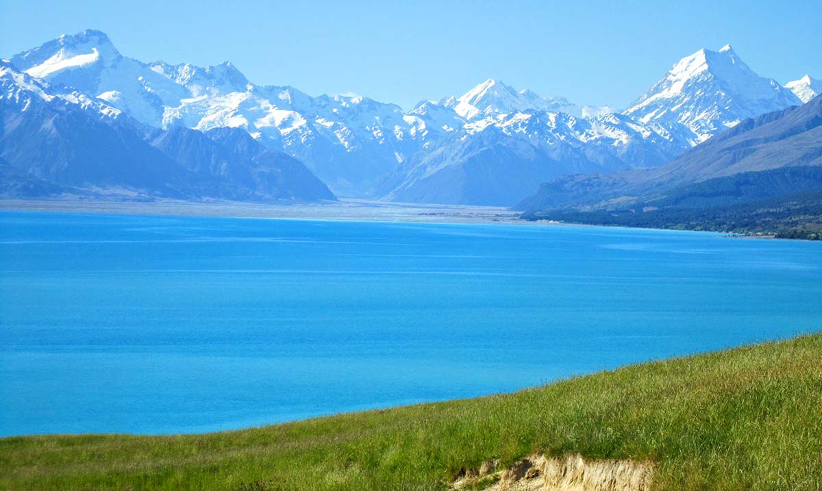 summer day bright blue lake, snow-capped mountains