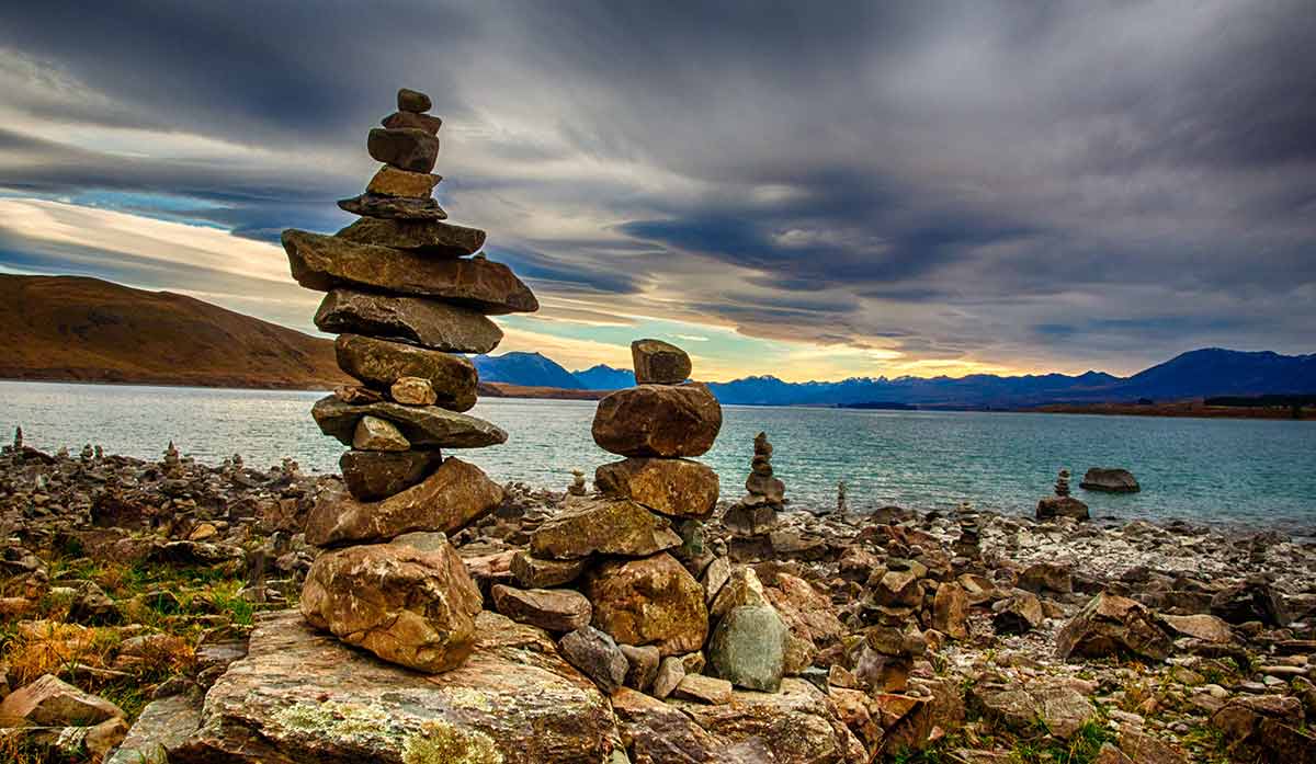 Rock cairns on a lake edge, moody sky
