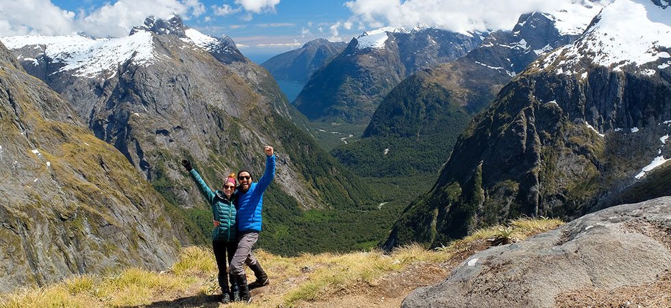 2 hikers posing for a photo high on a mountainside on the Milford Track