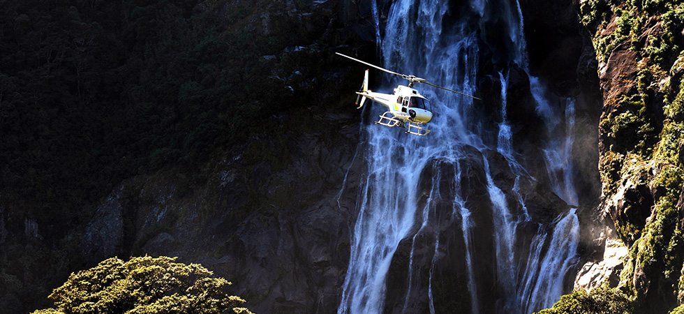 Helicopter flying near a waterfall