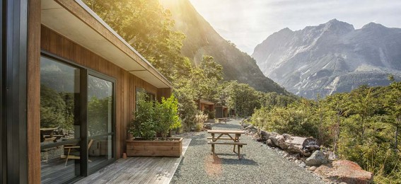 Wooden chalet, outdoor picnic table, mountains in the distance